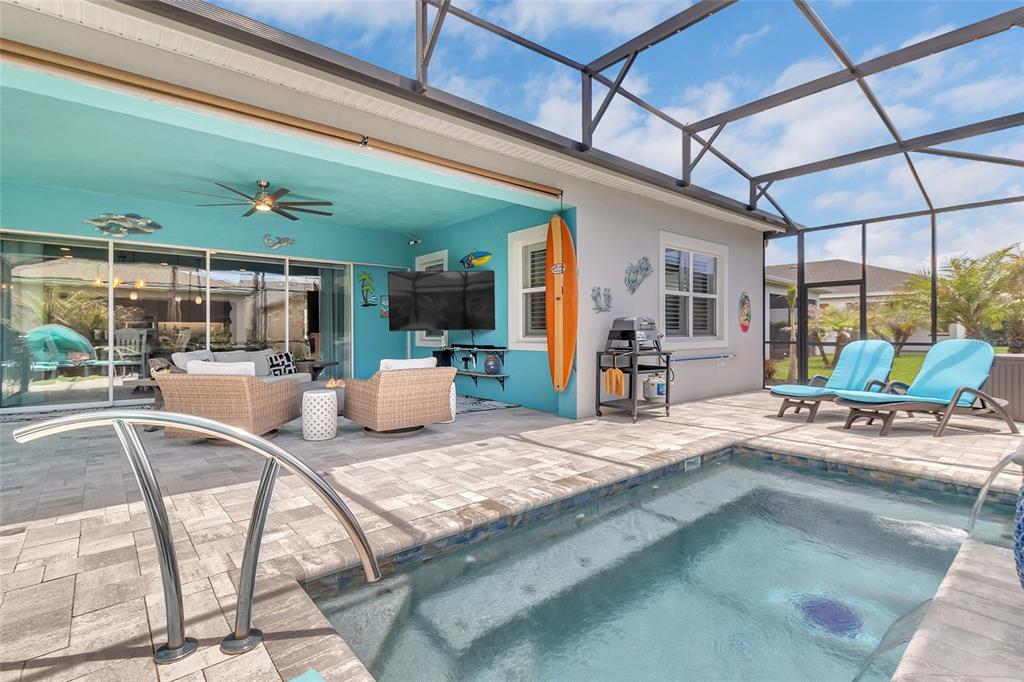 A screened-in patio features a small pool, lounge chairs, and a bright blue accent wall — 2764 GREENLANDS STREET, ST CLOUD, FL
