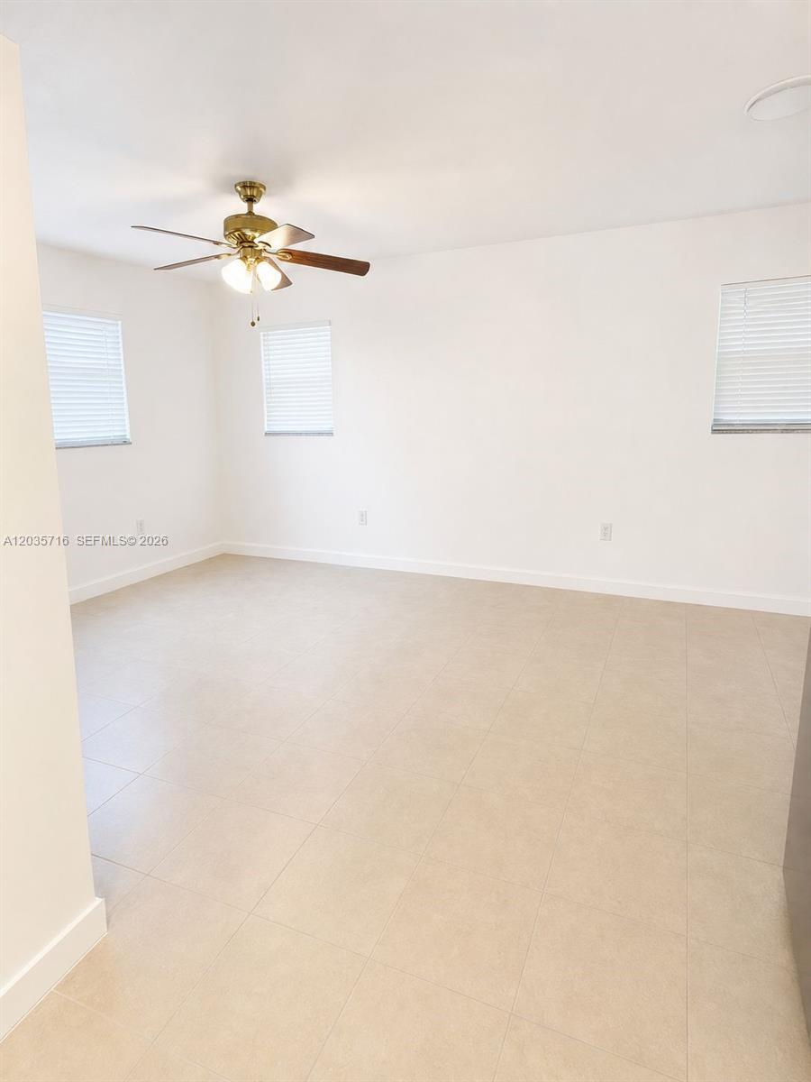 An empty room features white walls, tile flooring, and a ceiling fan with lights — 6228 NW 4th Ave # 2, Miami FL 33150, MIAMI, FL