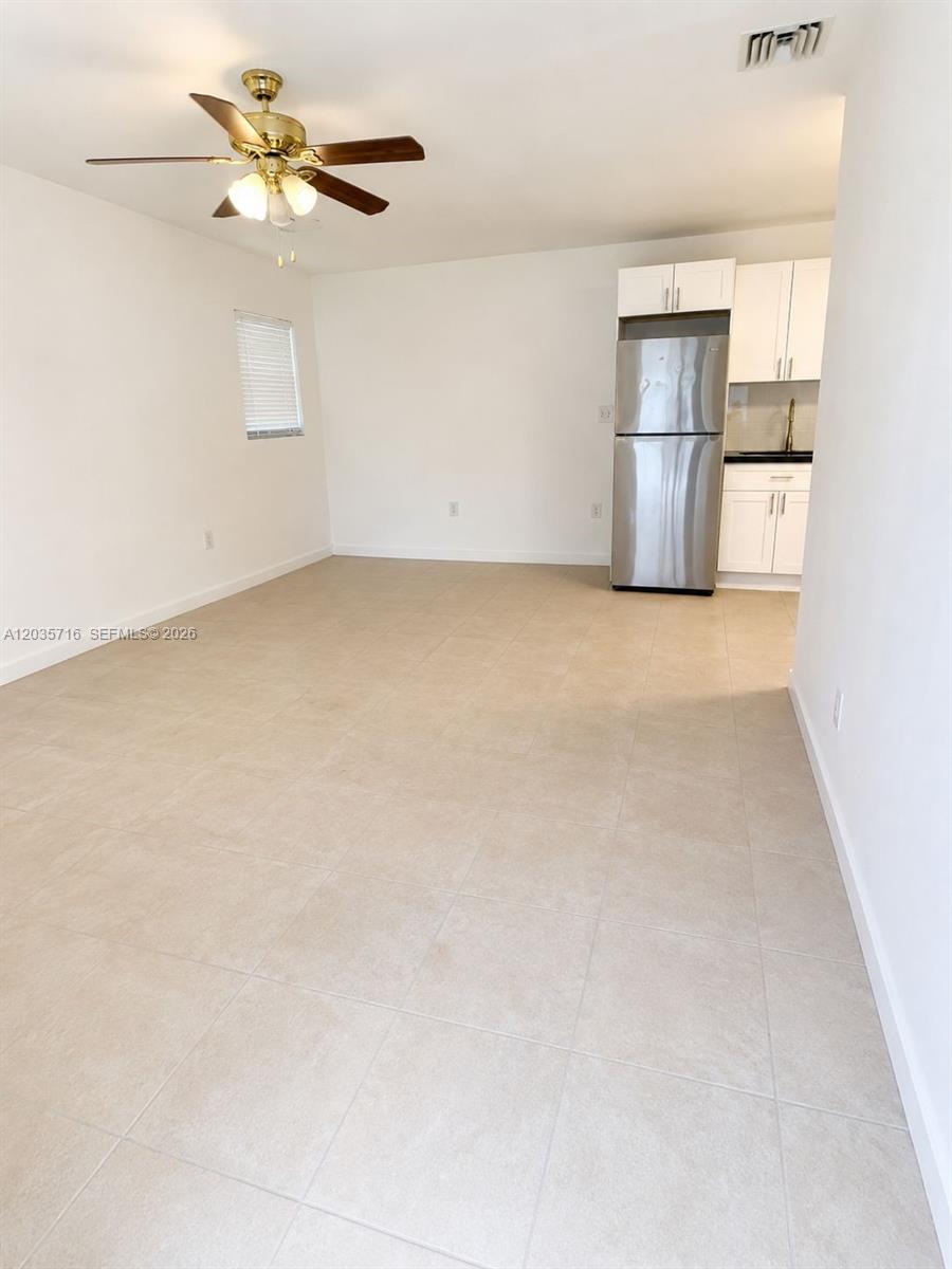 An open-concept room features light tile flooring, a ceiling fan, and a small kitchen area — 6228 NW 4th Ave # 2, Miami FL 33150, MIAMI, FL