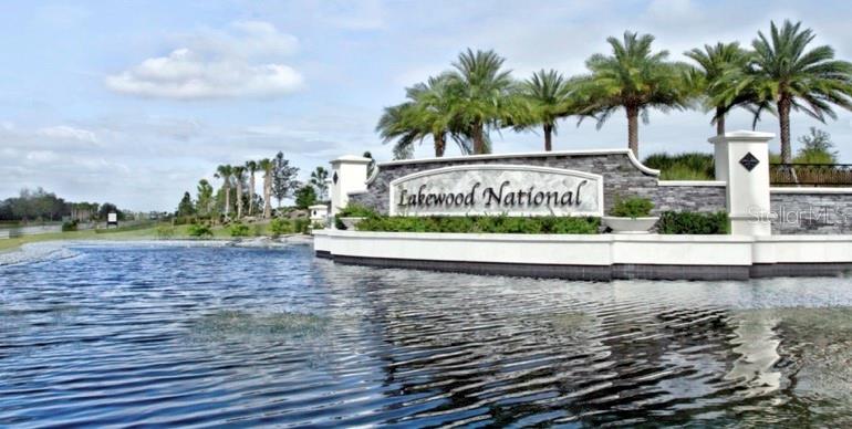 A stone monument sign for Lakewood National stands behind a pond with palm trees — 16804 VARDON TERRACE UNIT 108, BRADENTON, FL