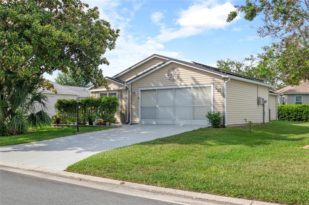 A beige single-story house with a screened garage door and a concrete driveway — 521 SAN PEDRO DRIVE, THE VILLAGES, FL