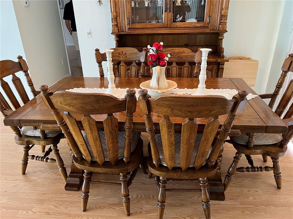 A wooden dining set with chairs and a hutch sits on a light wood floor — 1232 ZAPATA PLACE, LADY LAKE, FL