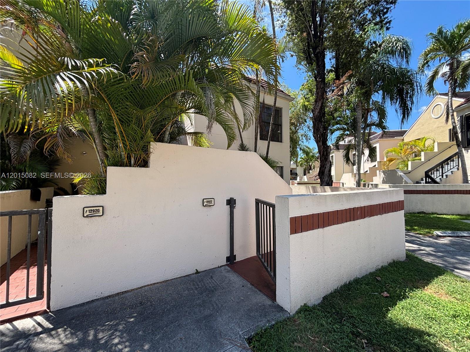 A low stucco wall with two address plaques separates two gated entrances to a residence — 12922 SW 88th Ter # 206, Miami FL 33186, MIAMI, FL