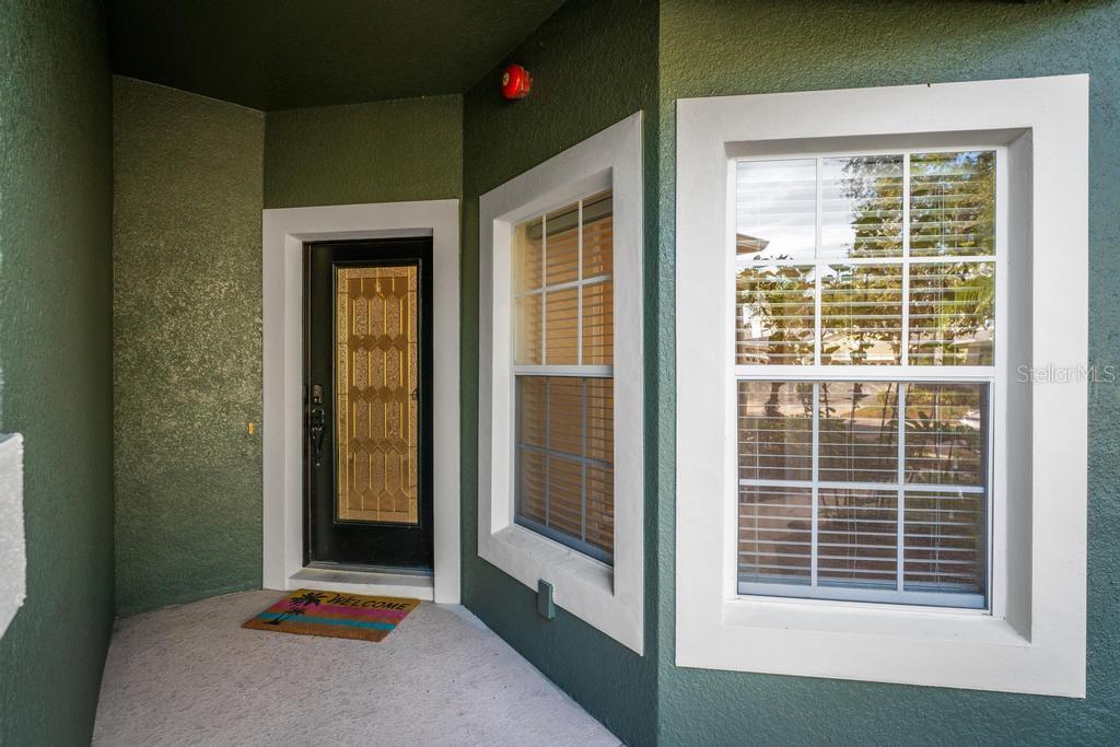 A front entryway features a dark door with glass panels, two windows, and a welcome mat — 868 STONECHASE LANE, LAKE MARY, FL