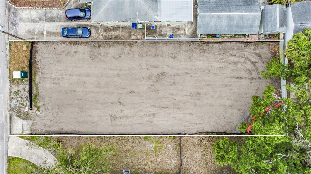 An aerial view shows a rectangular, cleared vacant lot bordered by residential properties and trees — 607 N MATANZAS AVENUE, TAMPA, FL