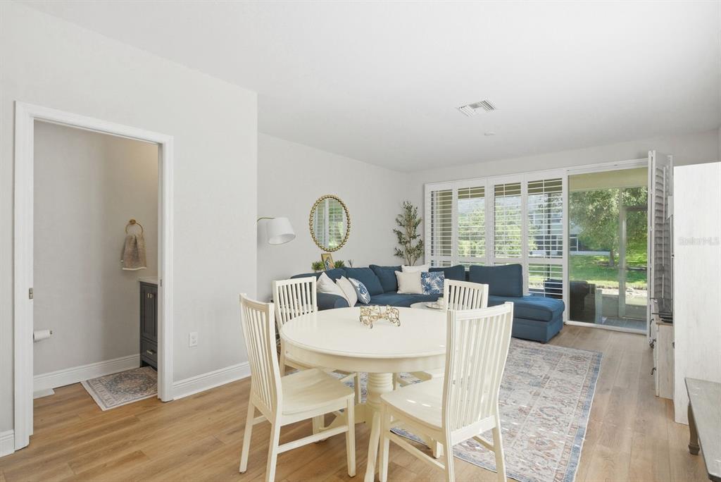 A dining area with a white table and chairs opens into a living room — 336 HARBOR RIDGE DRIVE, PALM HARBOR, FL