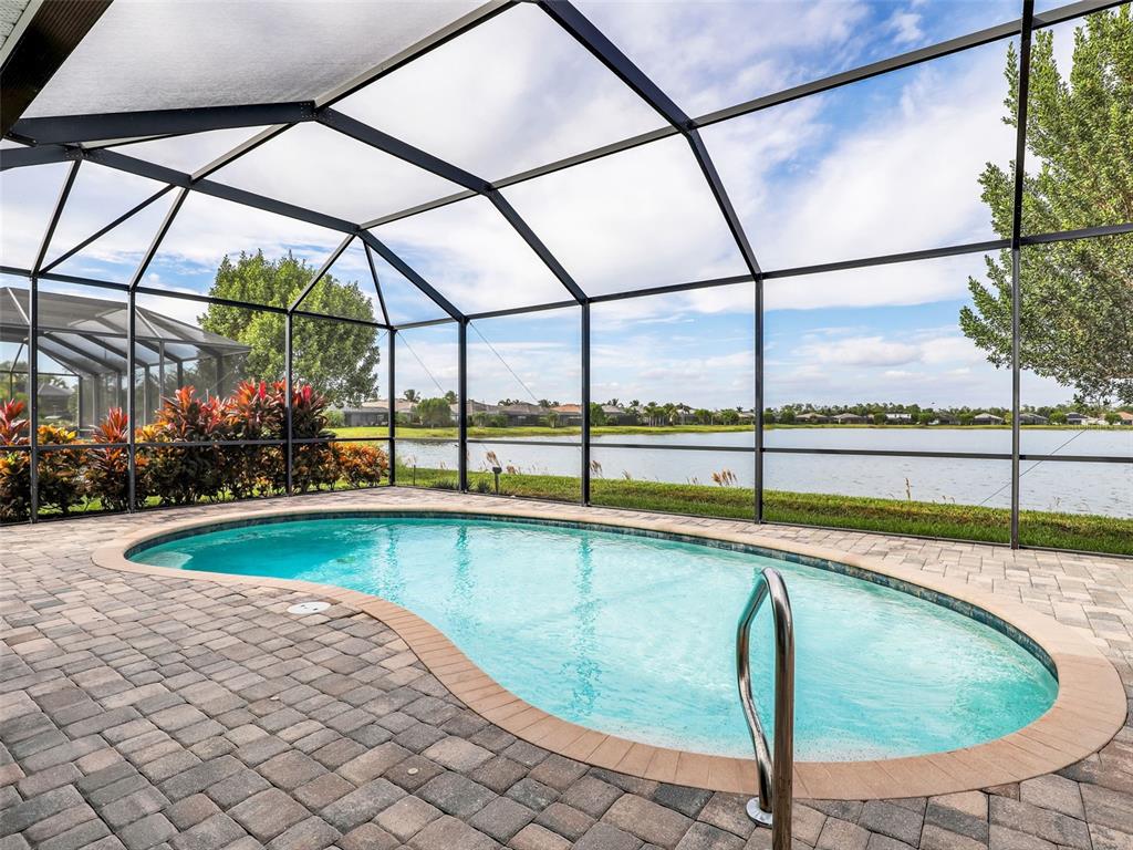 A light blue single-story house features a three-car garage, palm trees, and a paved driveway — 16391 BONITA LANDING CIRCLE, BONITA SPRINGS, FL
