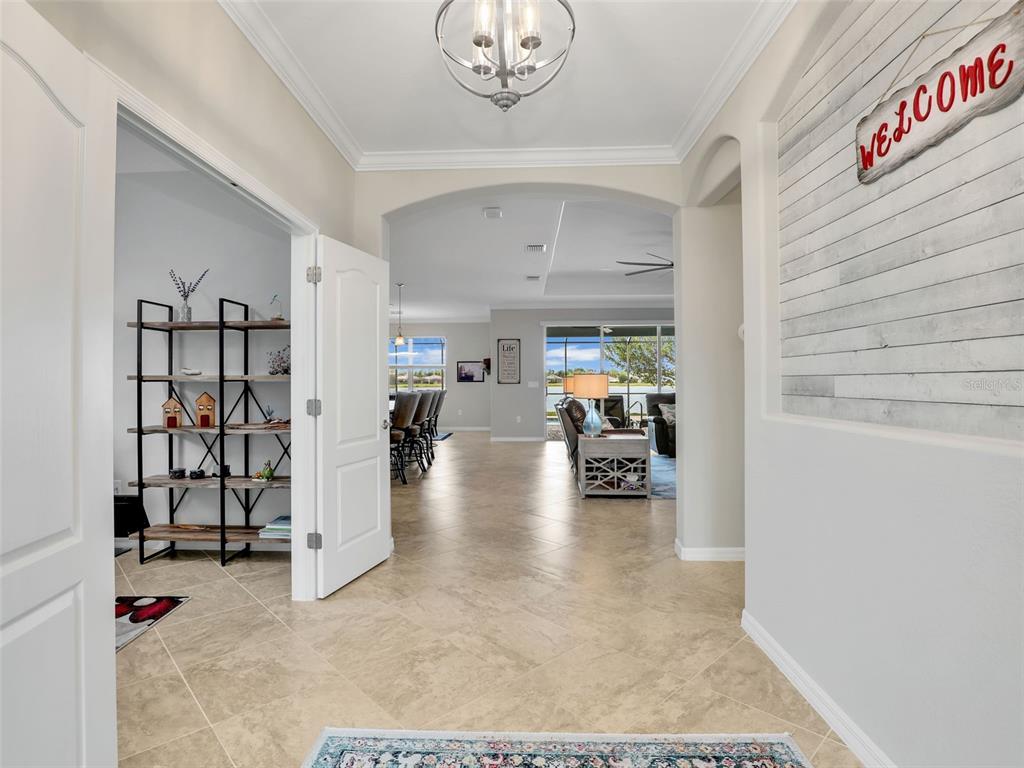 A screened-in pool patio overlooks a lake at sunset with a paved deck — 16391 BONITA LANDING CIRCLE, BONITA SPRINGS, FL