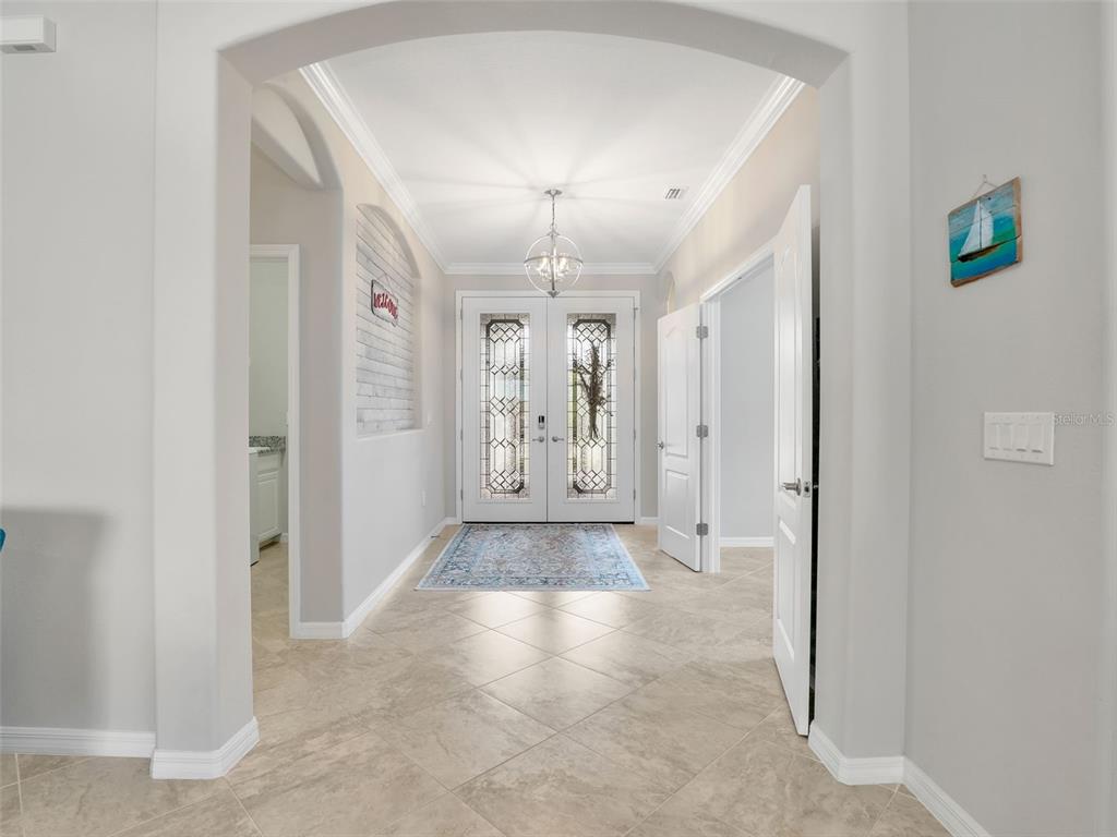 A kidney-shaped swimming pool sits on a paved patio enclosed by a screened lanai — 16391 BONITA LANDING CIRCLE, BONITA SPRINGS, FL