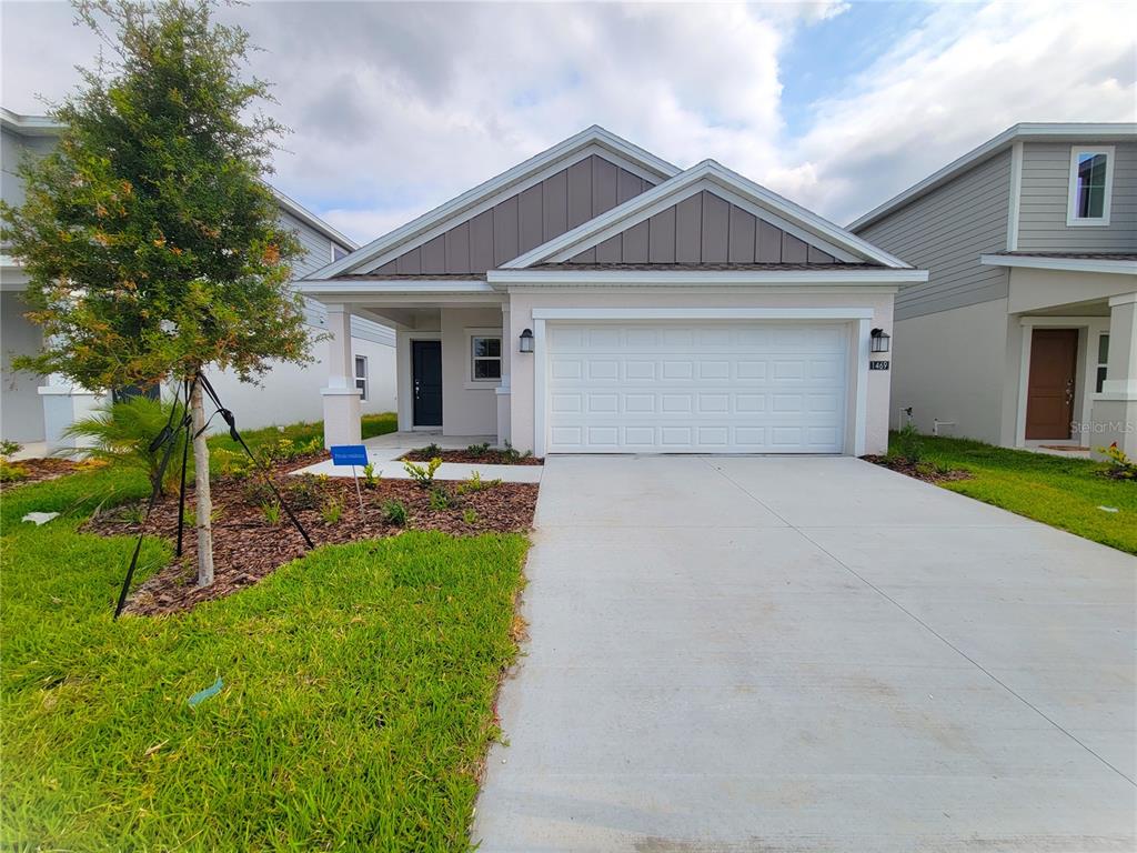 A single-story house with a white garage, gray siding, and a small front yard — 1469 DEEPWATER CIRCLE, EAGLE LAKE, FL