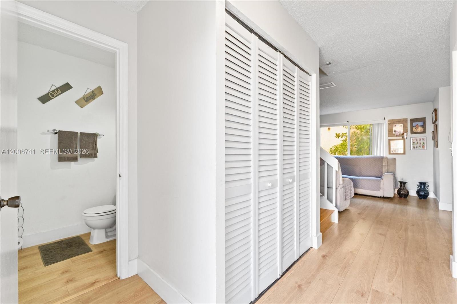 A hallway features a small bathroom, a louvered closet, and a view into a living area — 6235 Kendale Lakes Cir # 247, Miami FL 33183, MIAMI, FL
