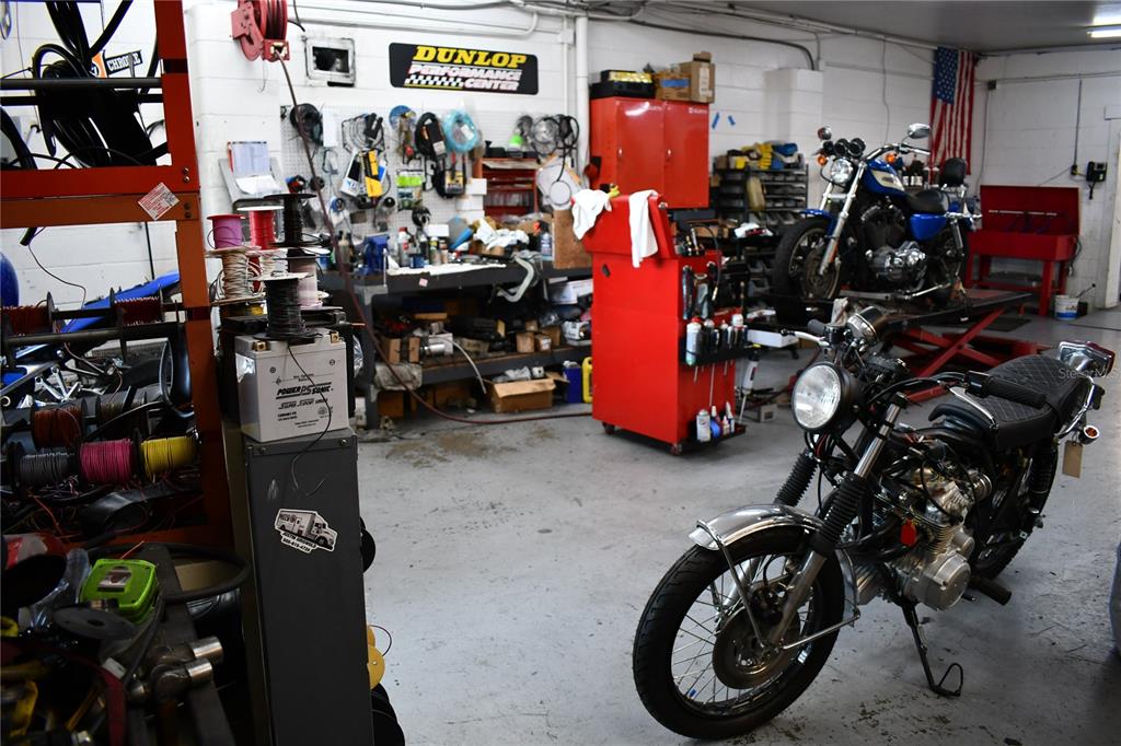 A motorcycle repair shop features two motorcycles, a red tool chest, and various workshop tools — 2702 E 7TH AVENUE, TAMPA, FL