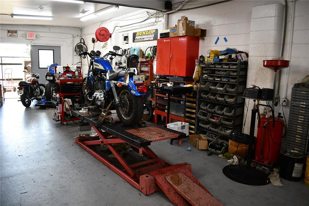 A motorcycle repair shop features a blue motorcycle on a lift and various tools — 2702 E 7TH AVENUE, TAMPA, FL