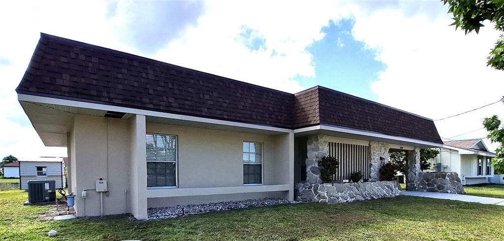 A single-story house with a mansard roof, stucco walls, and a stone-accented front porch — 5290 NEVILLE TERRACE, PORT CHARLOTTE, FL