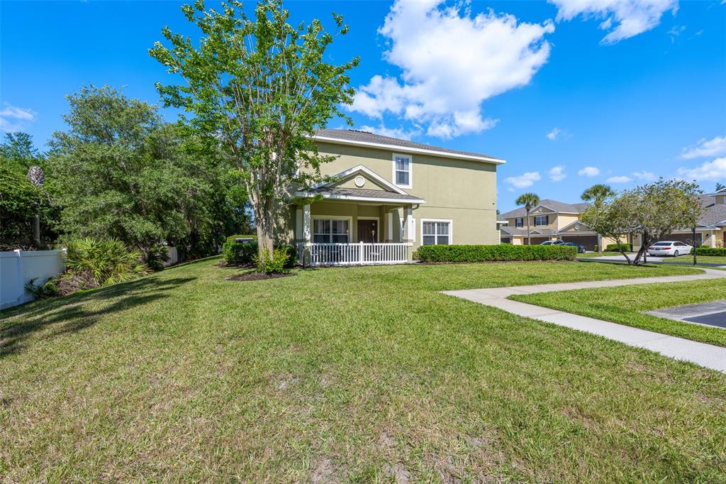 A two-story light green house features a covered front porch with a white railing — 8519 BROKEN WILLOW COURT, TAMPA, FL