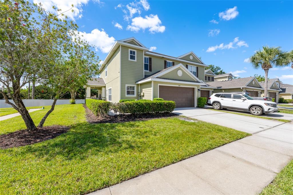 A two-story light green house with a two-car garage and a white SUV parked outside — 8519 BROKEN WILLOW COURT, TAMPA, FL