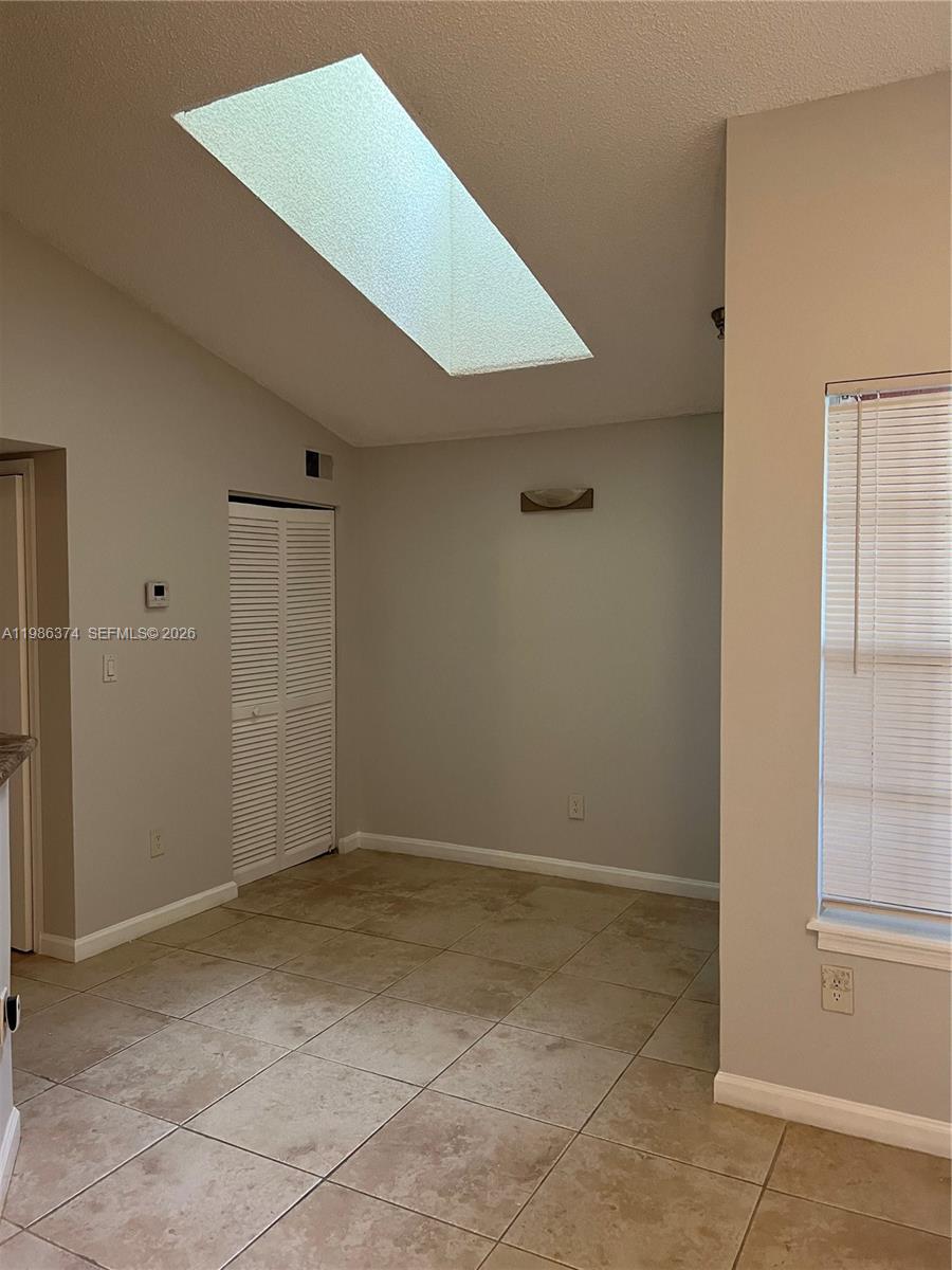This room features tile flooring, a skylight, a louvered closet door, and a window — 1385 Crystal Way # L, Delray Beach FL 33444, DELRAY BEACH, FL