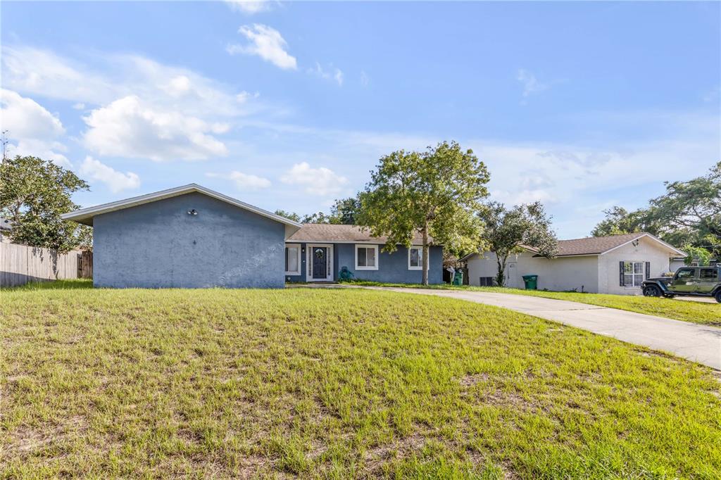 A blue single-story house with a concrete driveway and a large front lawn — 2550 VESPERO STREET, DELTONA, FL