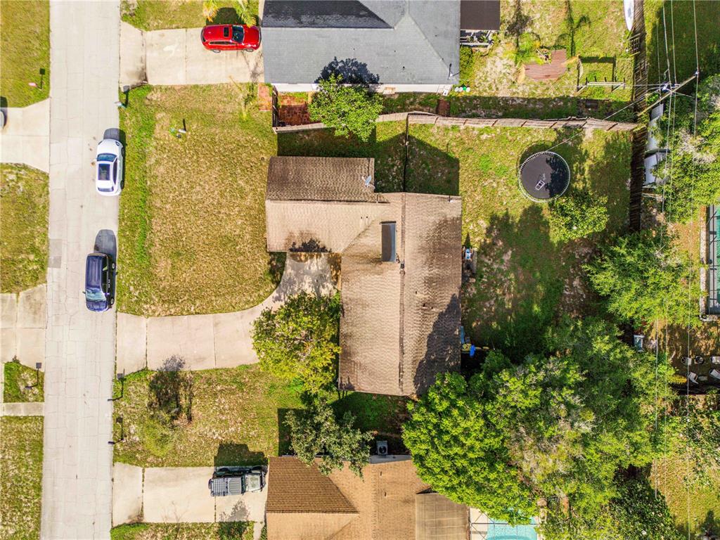 An aerial view shows a residential house with a large backyard, trampoline, and driveway — 2550 VESPERO STREET, DELTONA, FL