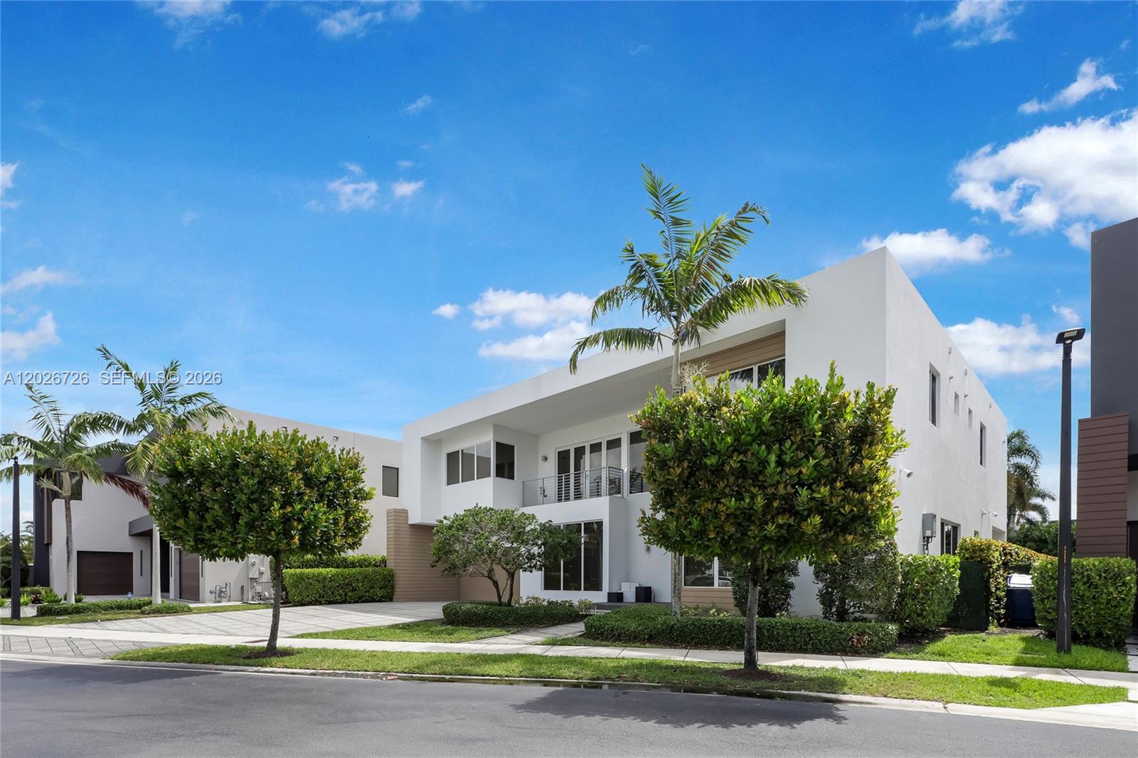 A modern two-story white house with a balcony, palm trees, and a paved driveway — 7441 NW 102nd Ct, Doral FL 33178, DORAL, FL