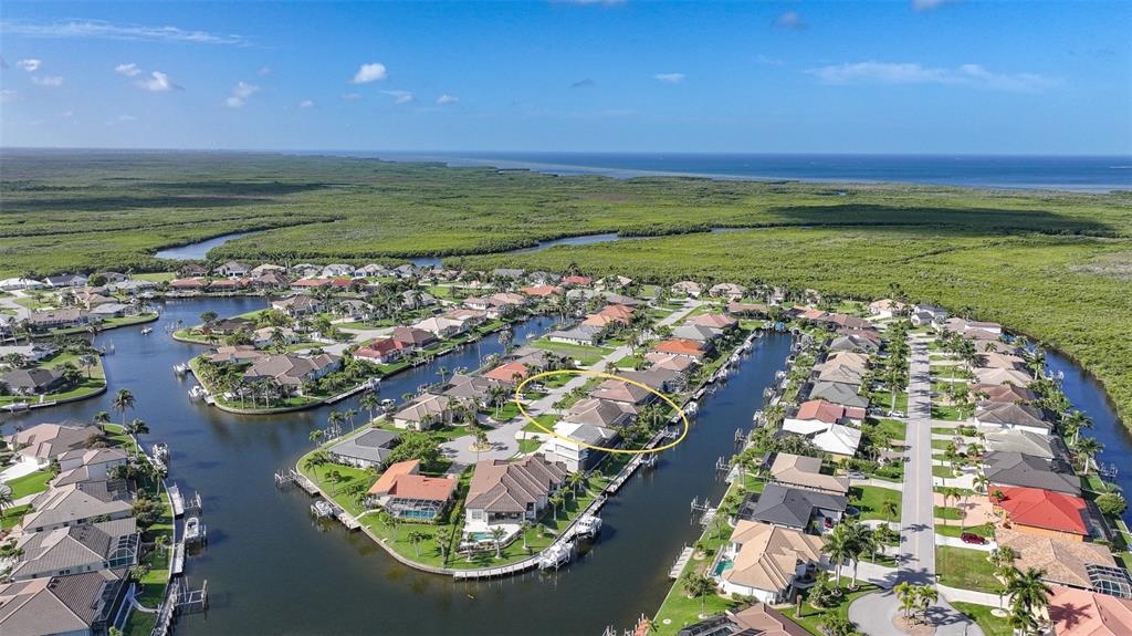 An aerial view shows a residential neighborhood with houses situated along canals and mangroves — 718 ANTALYA COURT, PUNTA GORDA, FL