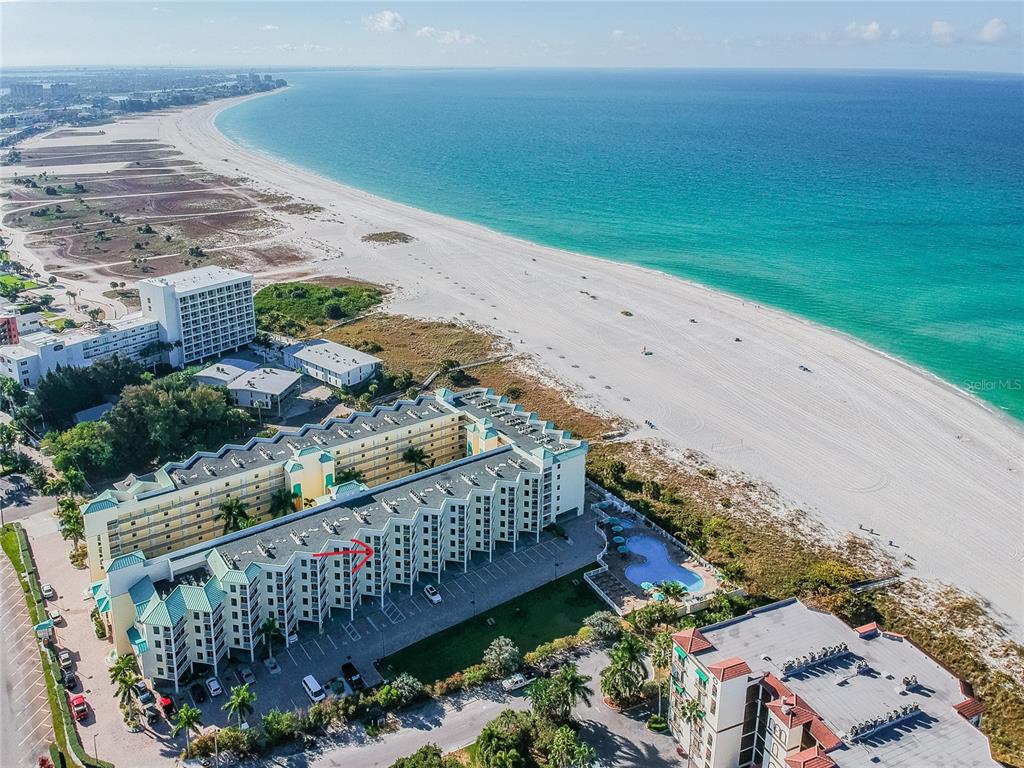 An aerial view shows a large beachfront resort complex with a pool and parking lot — 12000 GULF BOULEVARD UNIT 309N, TREASURE ISLAND, FL