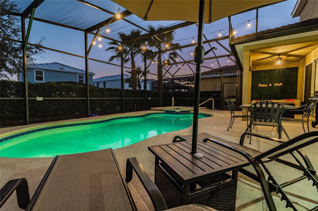 A screened-in patio features a swimming pool, a hot tub, and outdoor lounge furniture — 5352 OAKBOURNE AVENUE, DAVENPORT, FL