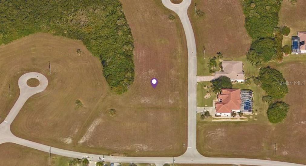 This aerial view shows a vacant residential lot situated between two paved cul-de-sac streets — 17451 MEDILLIN COURT, PUNTA GORDA, FL