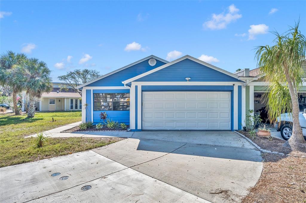 A living room features a brown sofa, an armchair, and a wall-mounted television — 4522 MARINE PARKWAY, NEW PORT RICHEY, FL