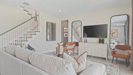 A living room features a staircase, a sofa, two armchairs, and a television on a console — 3116 LUMBER FALLS DRIVE, PLANT CITY, FL
