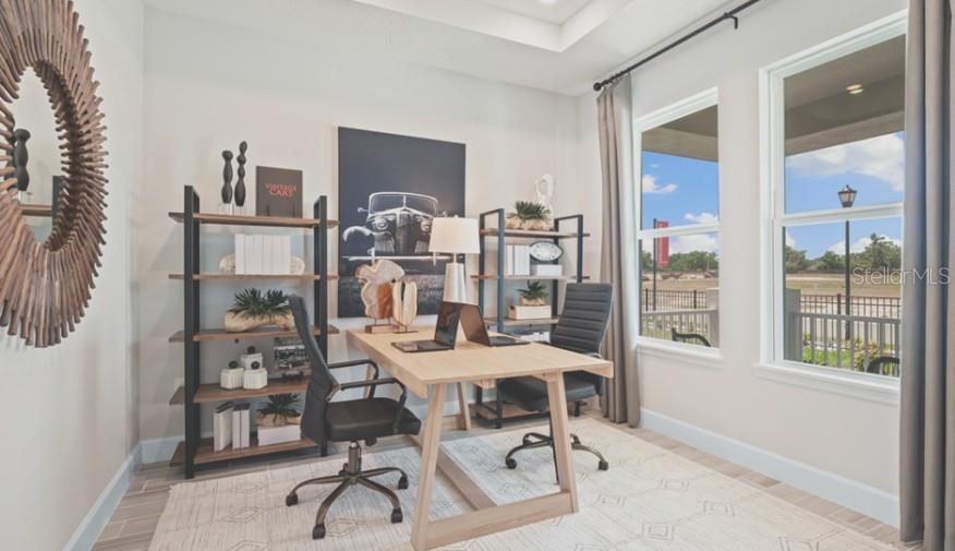 A home office features a wooden desk, two black chairs, shelving units, and large windows — 3116 LUMBER FALLS DRIVE, PLANT CITY, FL