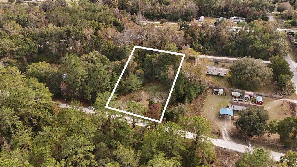 An aerial view shows a rectangular, wooded vacant lot outlined in white along a road — 0 SOUTHWEST 34TH COURT, OCALA, FL