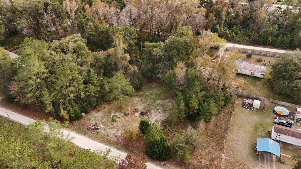 An aerial view shows a vacant, partially wooded lot bordered by a road and houses — 0 SOUTHWEST 34TH COURT, OCALA, FL