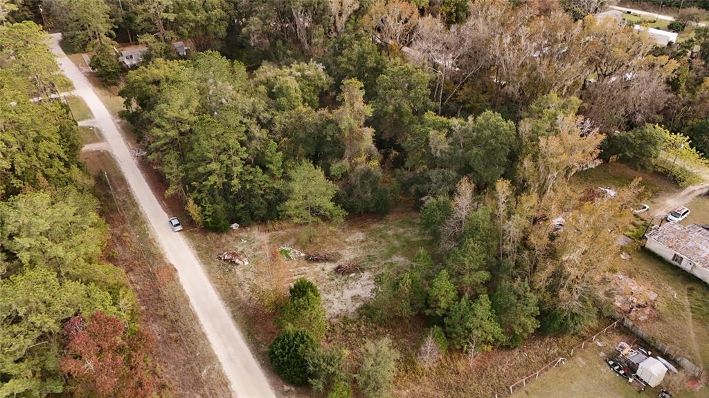 An aerial view shows a vacant, partially wooded lot adjacent to a dirt road — 0 SOUTHWEST 34TH COURT, OCALA, FL