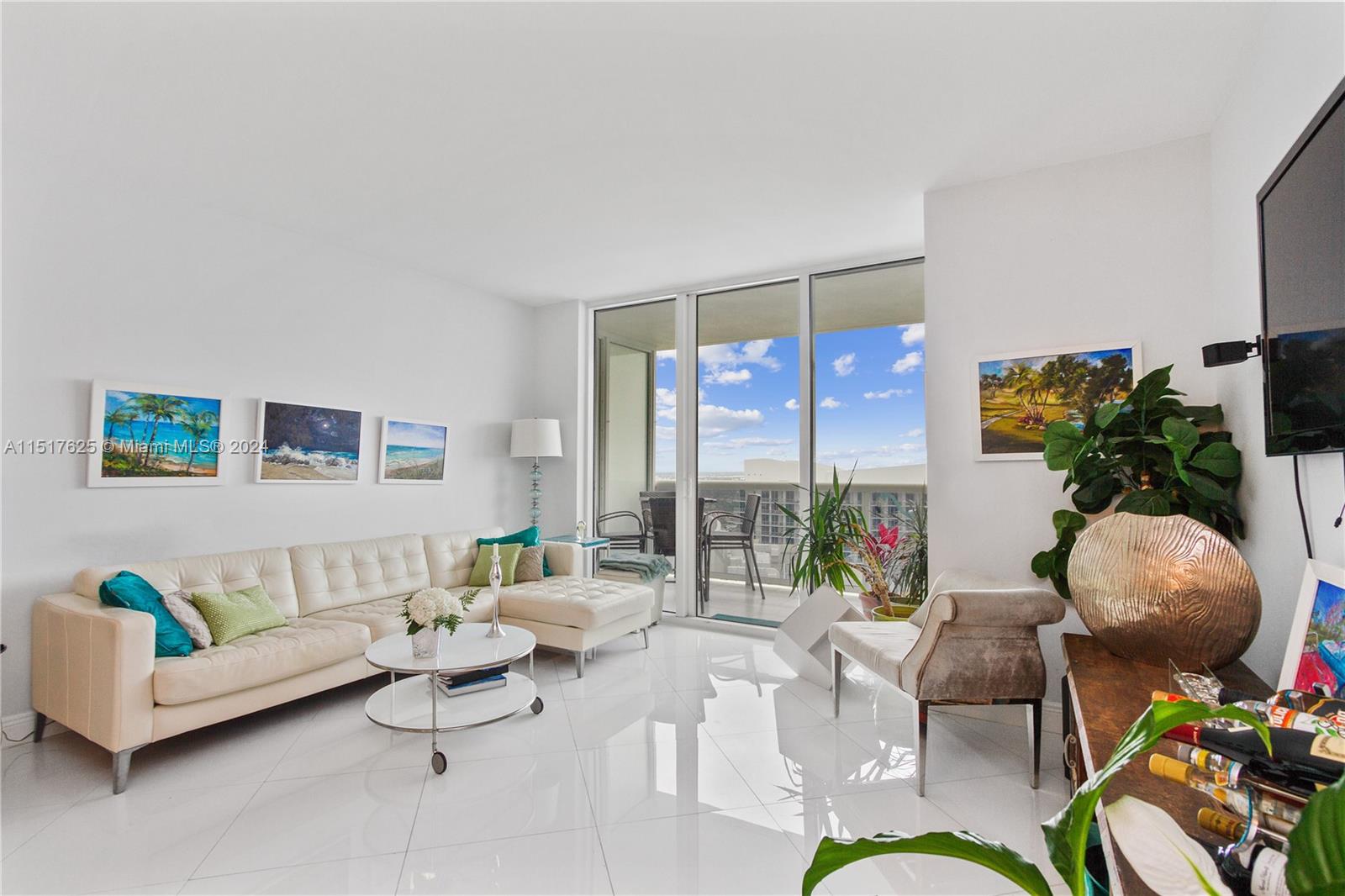 A bright living room features white tile floors, a sectional sofa, and a balcony view — 1830 S OCEAN DR, Hallandale Beach FL 33009, HALLANDALE BEACH, FL