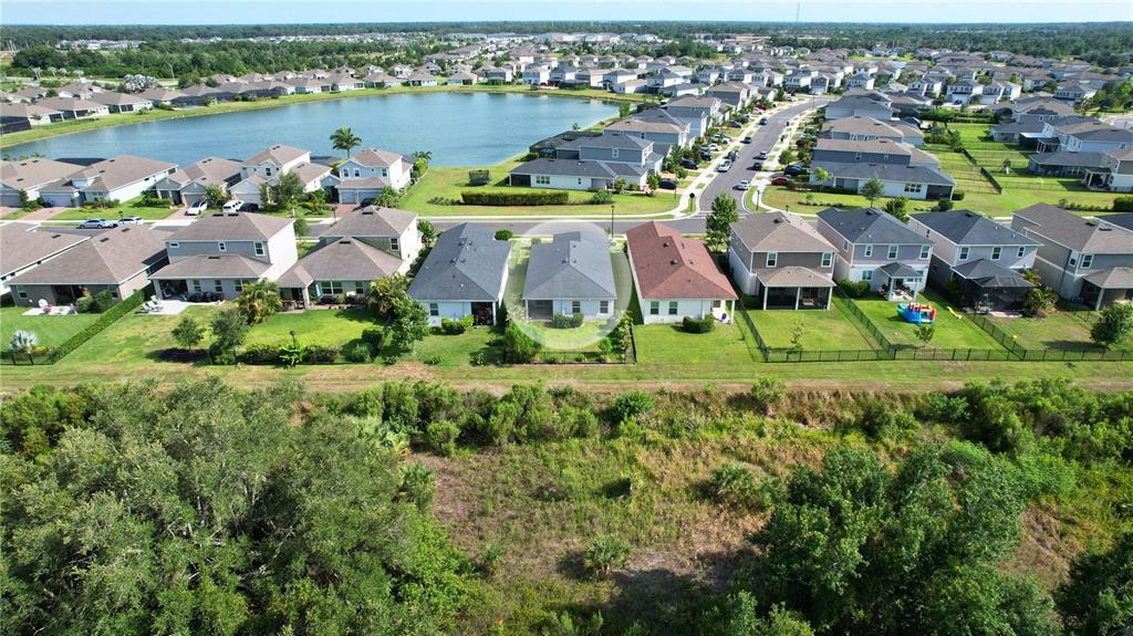 An aerial view shows a residential neighborhood with a highlighted house facing a large pond — 11636 LITTLE RIVER WAY, PARRISH, FL