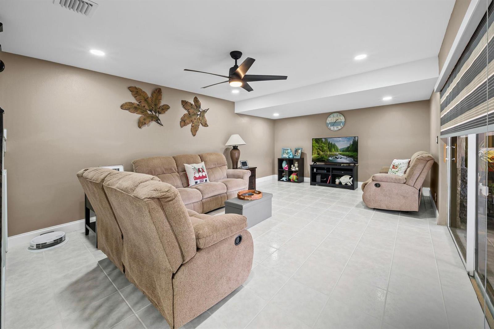 A living room with beige walls, tile flooring, a ceiling fan, and tan upholstered furniture — 747 NW 30th Avenue # D, Delray Beach FL 33445, DELRAY BEACH, FL