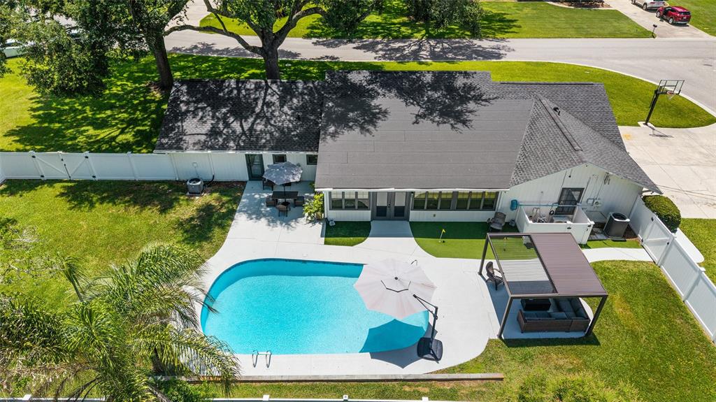 An aerial view shows a house with a swimming pool, patio, and pergola in a backyard — 3453 SE 25TH AVENUE, OCALA, FL