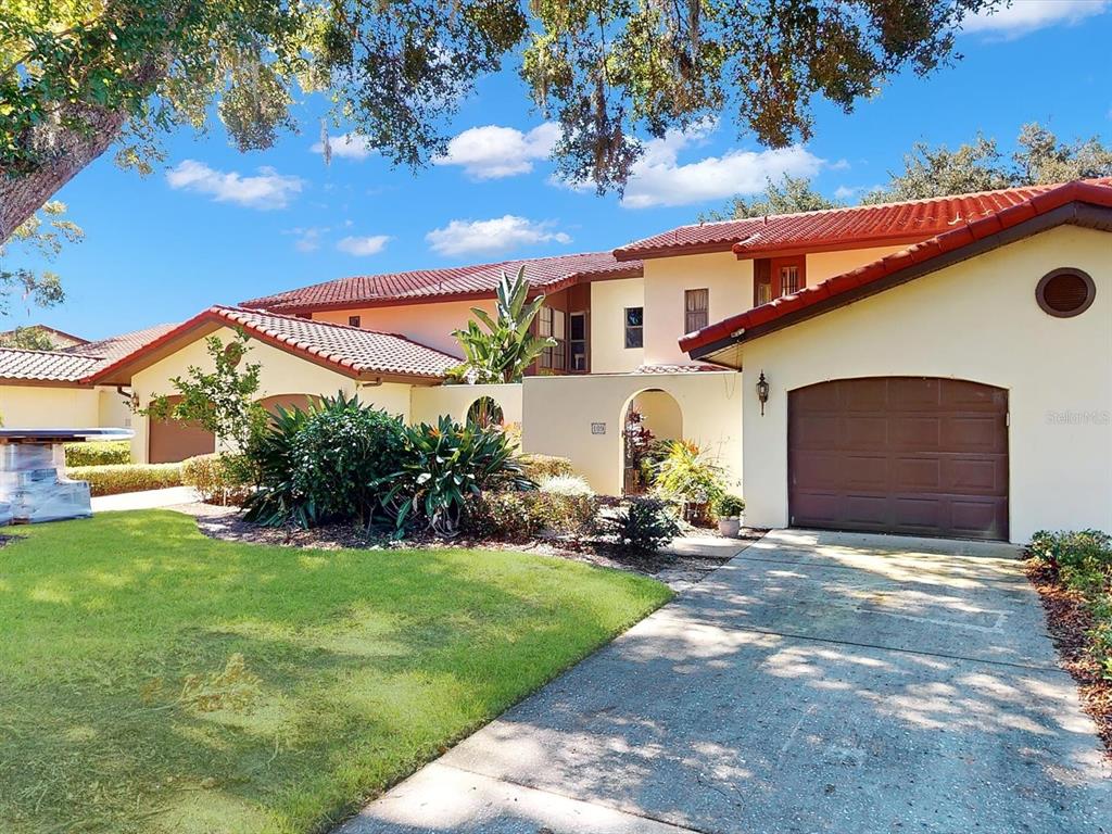A two-story house with a tile roof, a garage, and a landscaped front yard — 109 COVENTRY LANE, HAINES CITY, FL