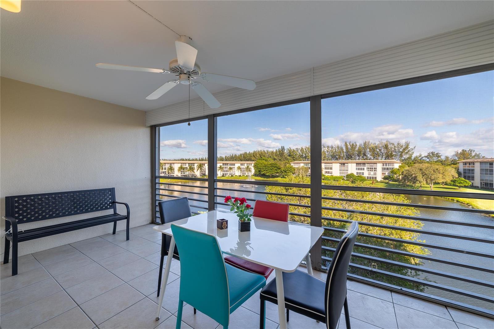 A screened-in balcony features a dining set, a bench, and a view of a lake — 1902 Bermuda Circle, Coconut Creek FL 33066, COCONUT CREEK, FL