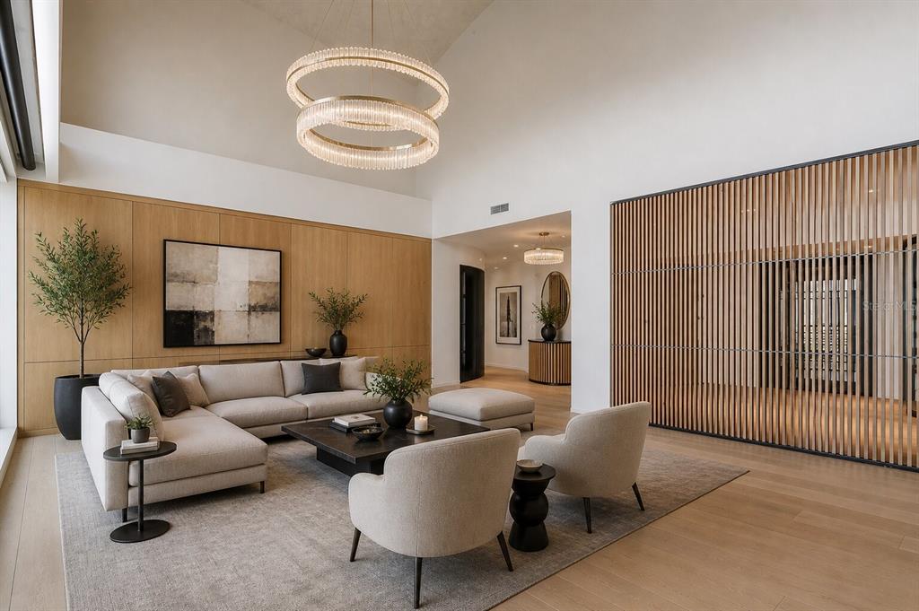 A modern living room features a sectional sofa, two armchairs, and a slatted wood wall — 1209 E CUMBERLAND AVENUE UNIT 2902, TAMPA, FL