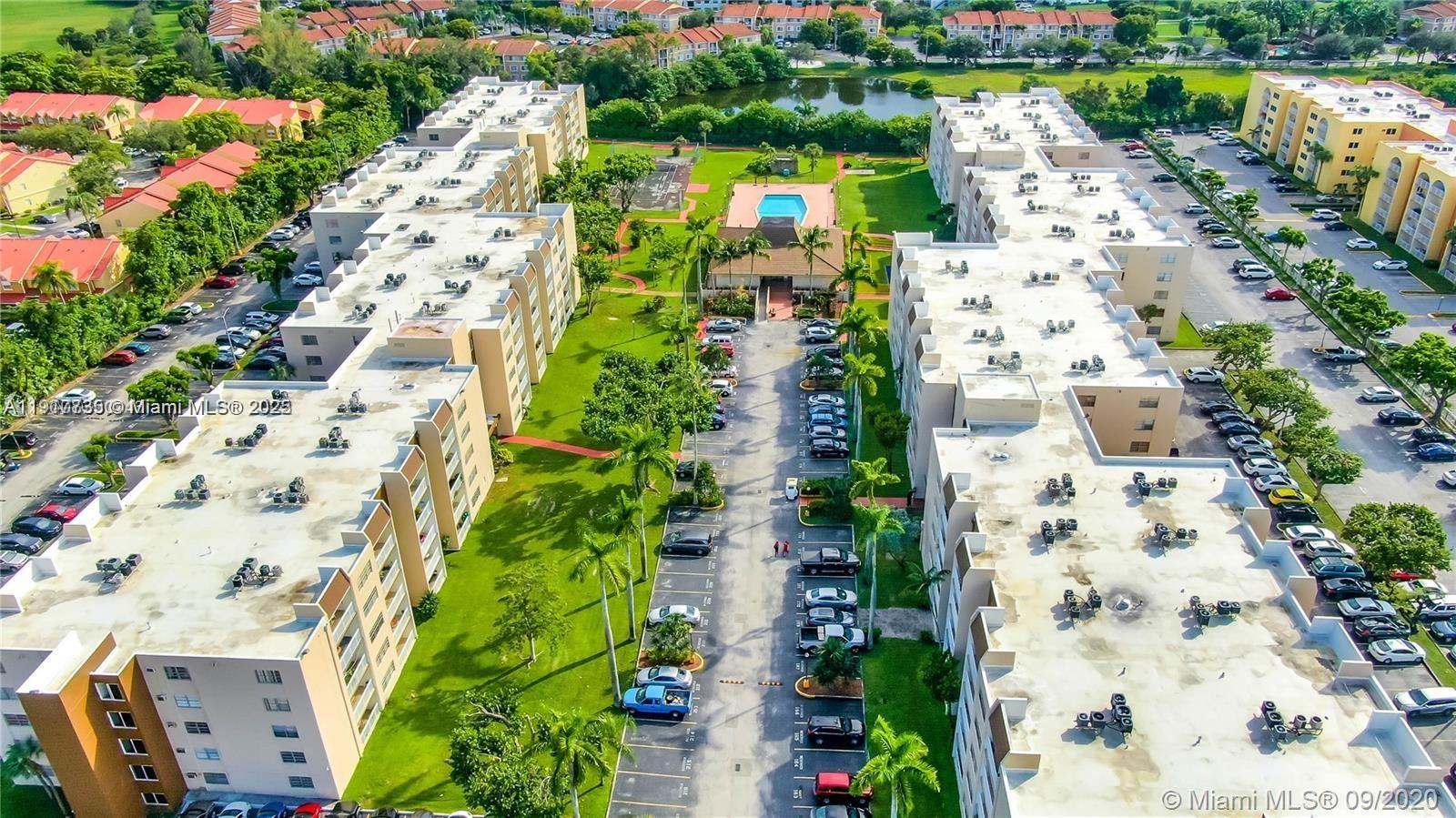 An aerial view shows two apartment buildings flanking a central parking lot and swimming pool — 6930 Miami Gardens Dr # 410, Hialeah FL 33015, HIALEAH, FL