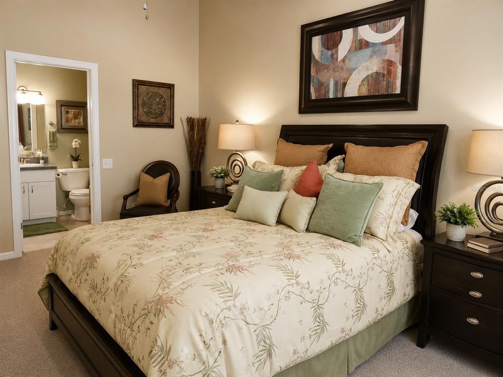 A bedroom features a queen bed with floral bedding, dark wood furniture, and an attached bathroom — 29914 ALTA VITA LANE, WESLEY CHAPEL, FL