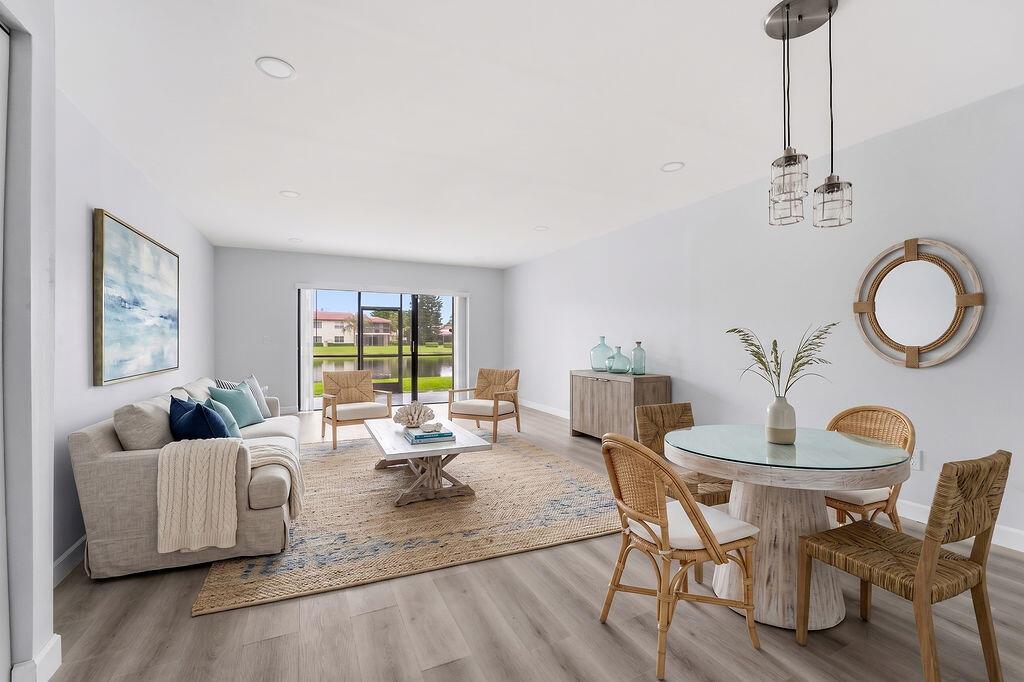 A bright living and dining area features light wood flooring, neutral furniture, and a glass-topped table — 21839 Arriba Real # 10g, Boca Raton FL 33433, BOCA RATON, FL