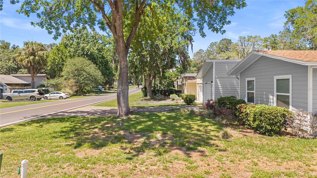 A gray house with a driveway sits next to a road lined with trees — 11801 NW 72ND TERRACE, ALACHUA, FL