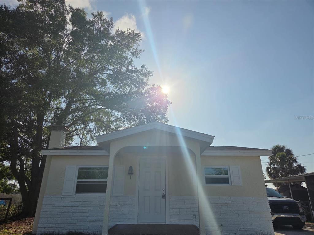 A single-story house with a white door, light-colored siding, and a stone-textured lower exterior — 13113 BARTOW STREET, HUDSON, FL