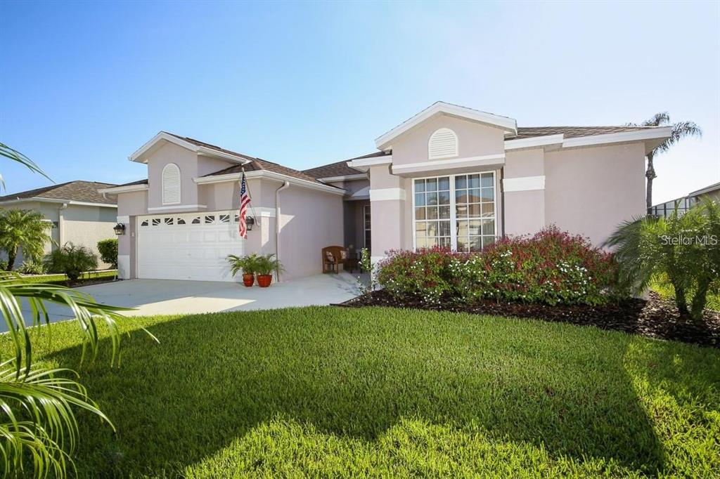 A single-story house with a white garage, light-colored stucco exterior, and a manicured front lawn — 5041 47TH STREET W, BRADENTON, FL