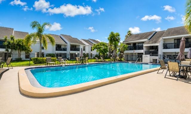 A swimming pool sits in the center of a courtyard surrounded by multi-story apartment buildings — 654 HAVEN PLACE UNIT 654, TARPON SPRINGS, FL