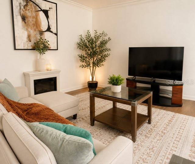 A living room features a sectional sofa, a glass-topped coffee table, and a television — 654 HAVEN PLACE UNIT 654, TARPON SPRINGS, FL