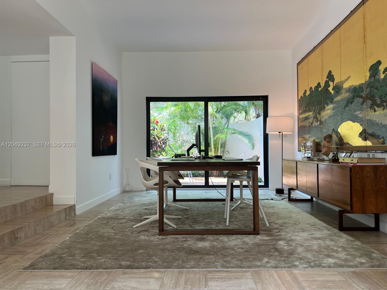 A home office features a wooden desk, white chairs, a large area rug, and a wall mural — 4101 Battersea Rd # 1, Miami FL 33133, MIAMI, FL